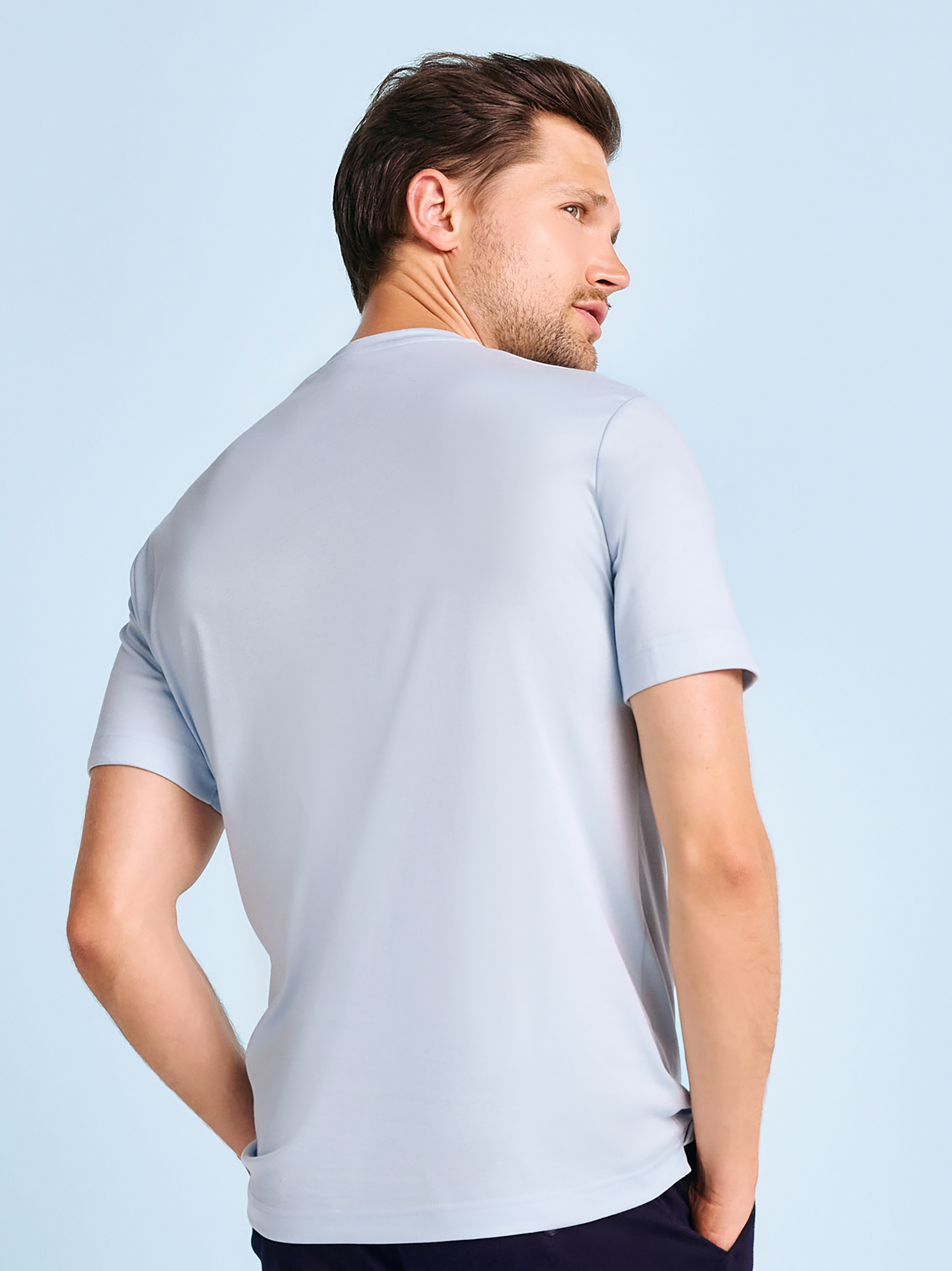 Mens T-shirt casual roundneck in solid light blue, back view worn by model