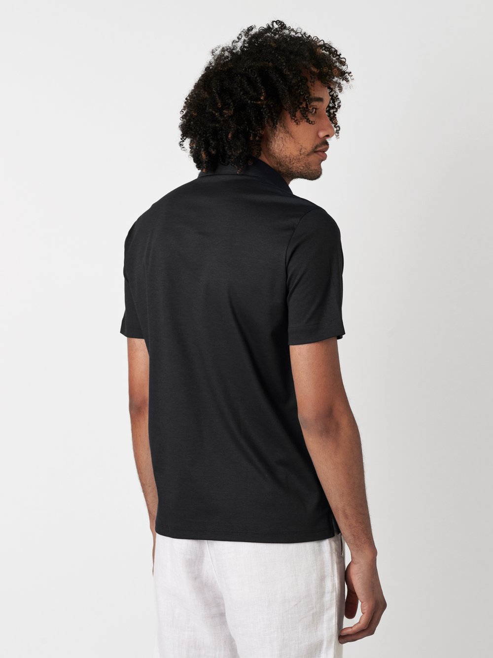 Herrenpolo Essential Kent in black pique, Rueckansicht am Model getragen