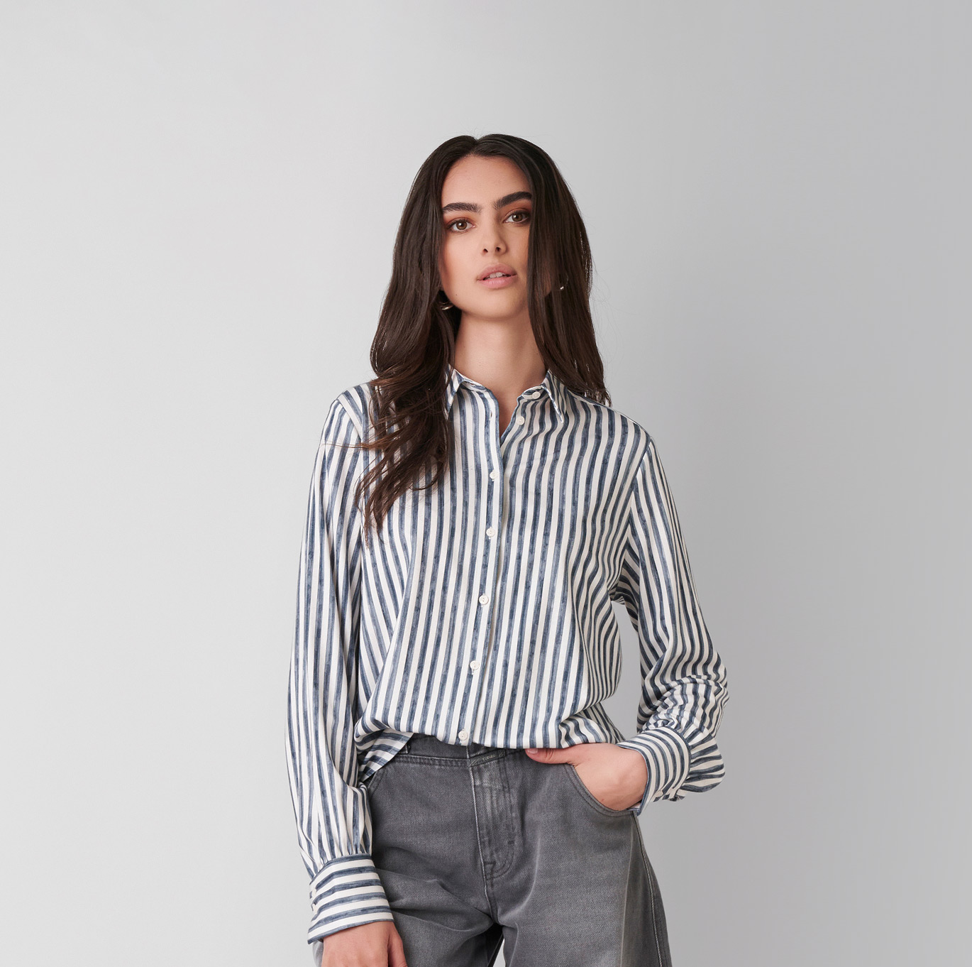 Frau in gestreifter Jersey-Bluse von DESOTO mit modernem, entspanntem Look – Rubrik Women.