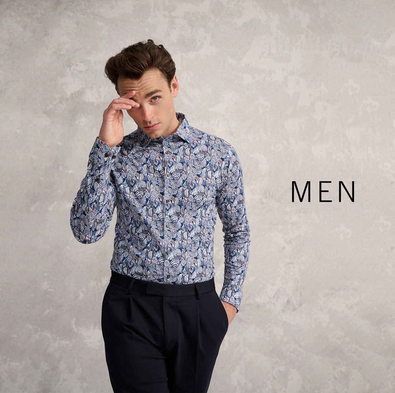 Mann in gemustertem Jersey-Hemd von DESOTO vor grauem Hintergrund – moderner Look der Men-Kollektion.
