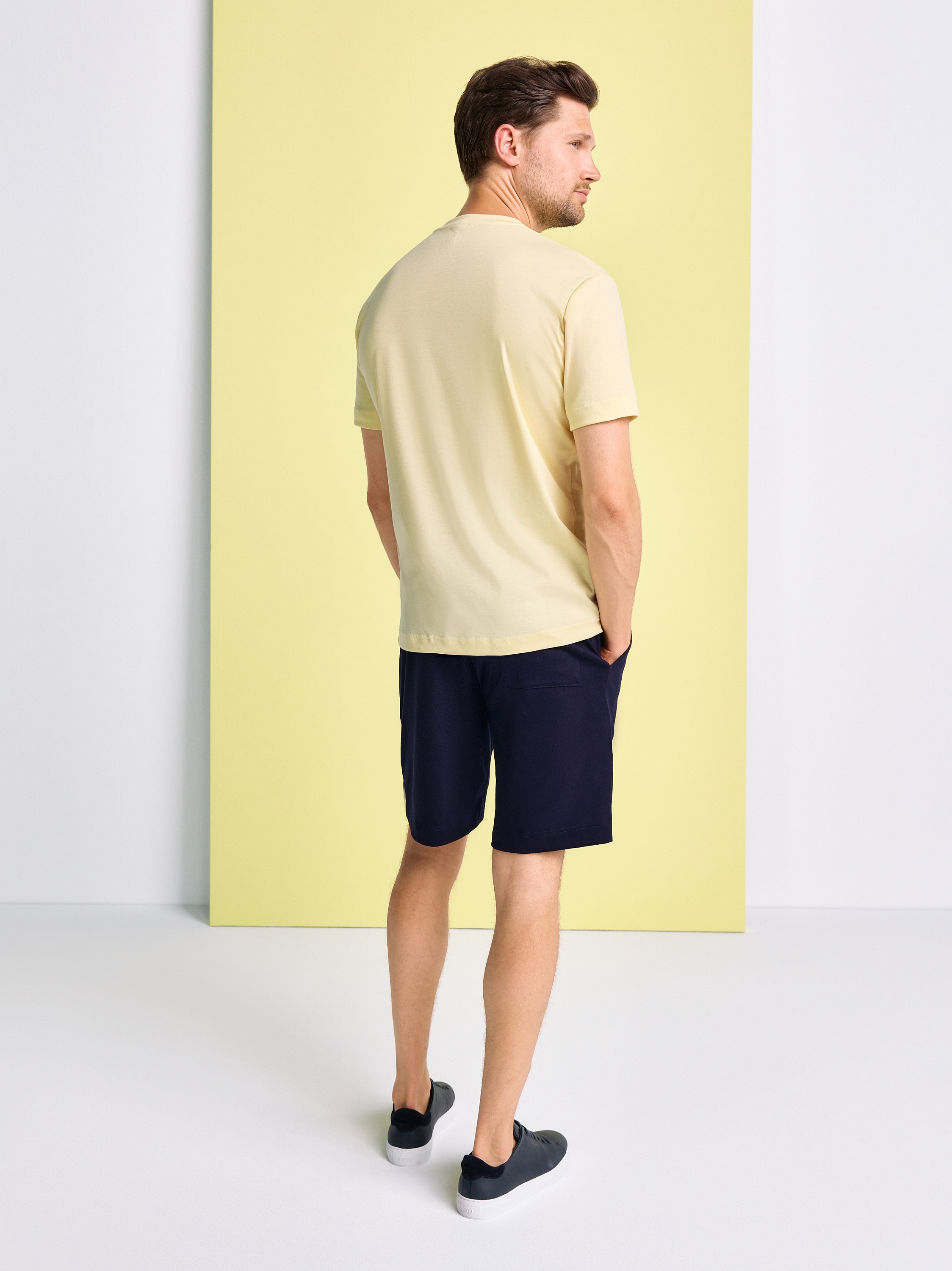 Mens T-shirt casual roundneck in solid yellow, back view worn by model