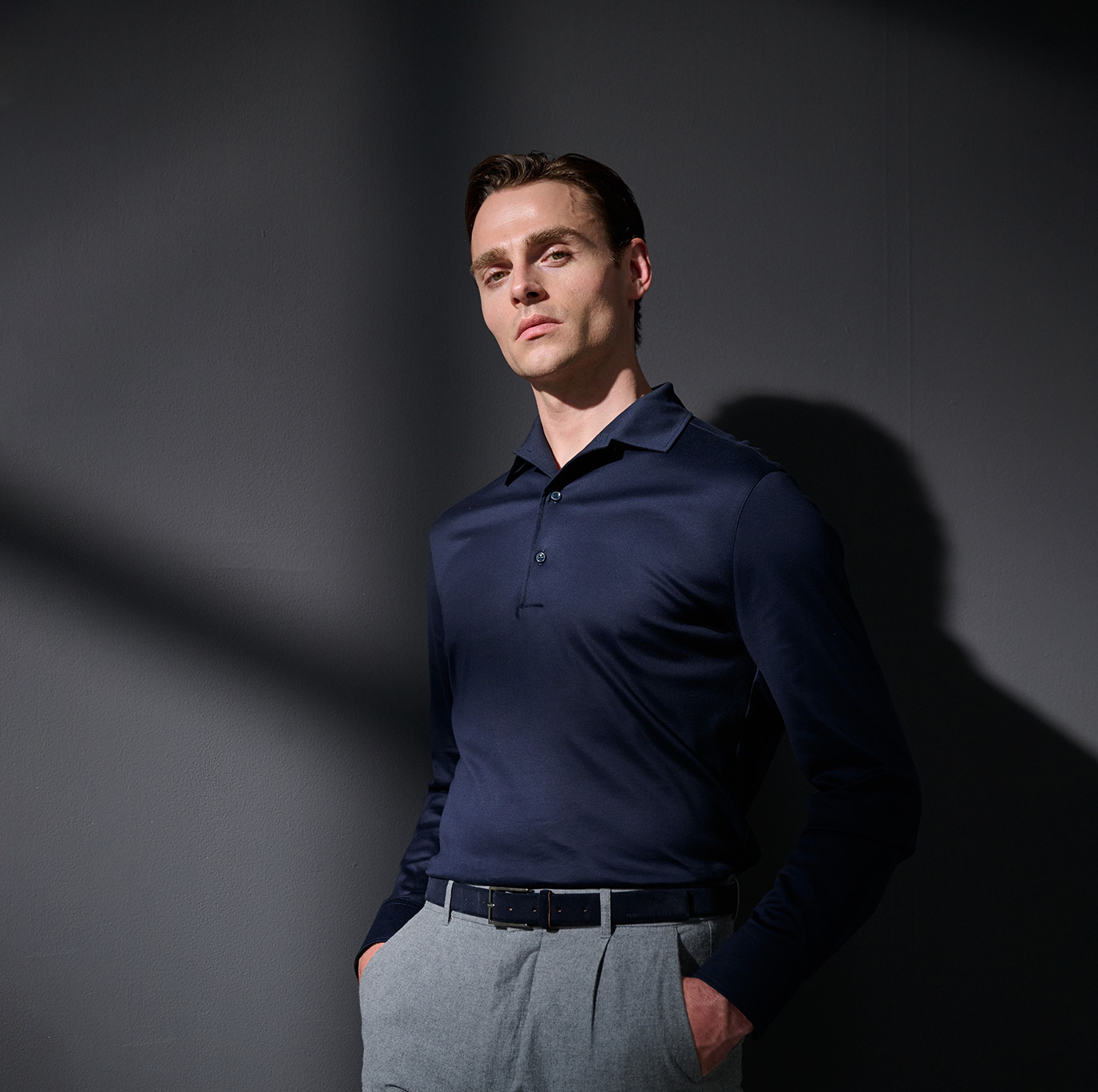 Mann in dunkelblauem Langarm-Poloshirt von DESOTO – eleganter Look der Luxury Line.