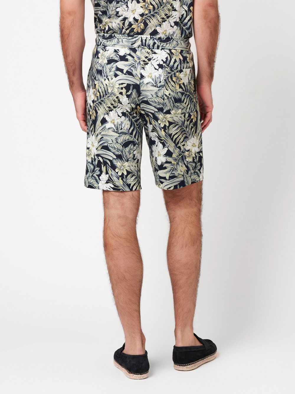 Mens shorts casual in pastel green flowers, back view worn by model